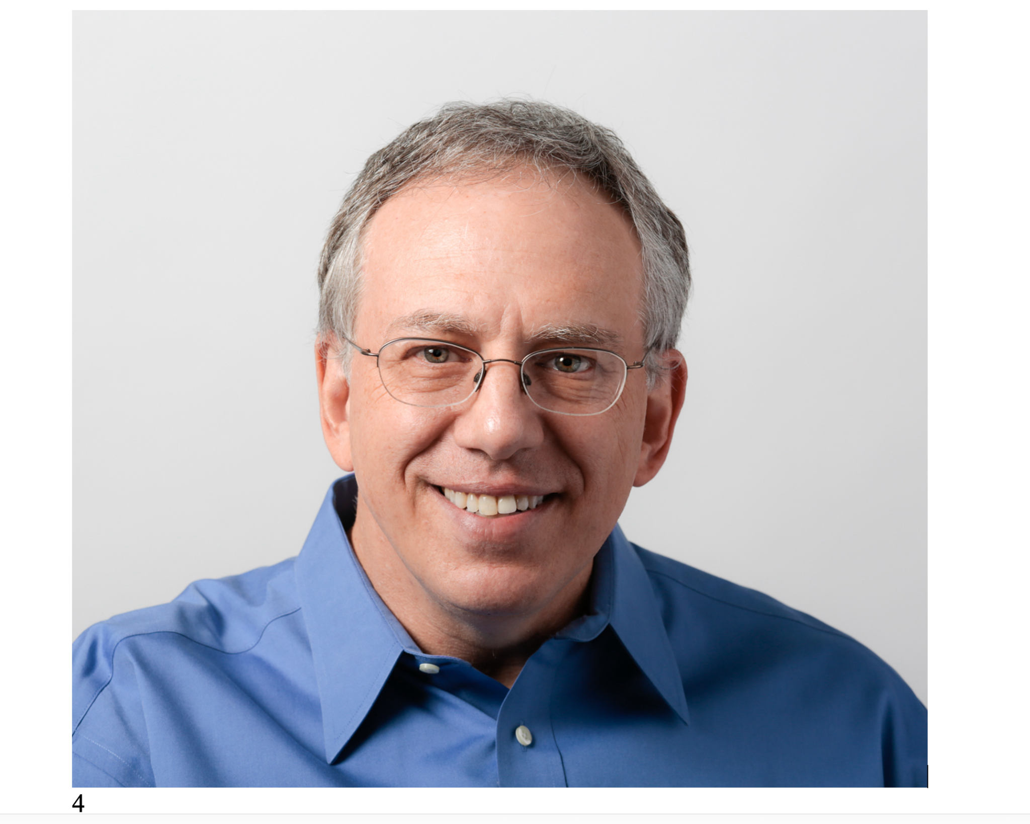 Jordan Gruber smiling, wearing glasses and a blue shirt